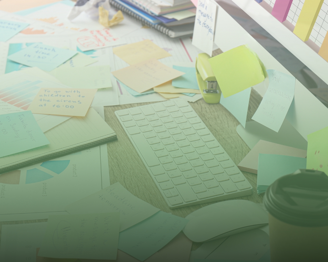 desk piled up with things to do including, post-its, graphs of accounting and tax tasks